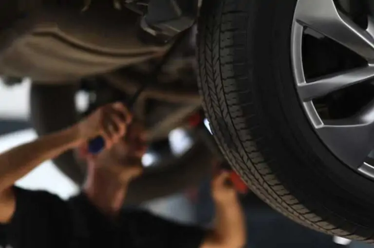 Meccanico che regola la scatola dello sterzo di un'auto